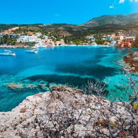 Beautiful Assos village, Kefalonia. Greece. White cruise yachts staying at anchor in beautiful