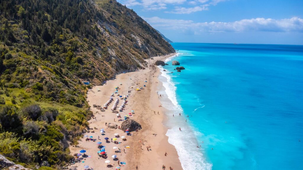 Drone shot of beautiful crystal clear turquoise and blue water at Megali Petra sandy beach Lefkada