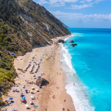 Drone shot of beautiful crystal clear turquoise and blue water at Megali Petra sandy beach Lefkada