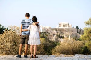 Greece, Athens, couple looking at The Acropolis and Parthenon from Areopagus.