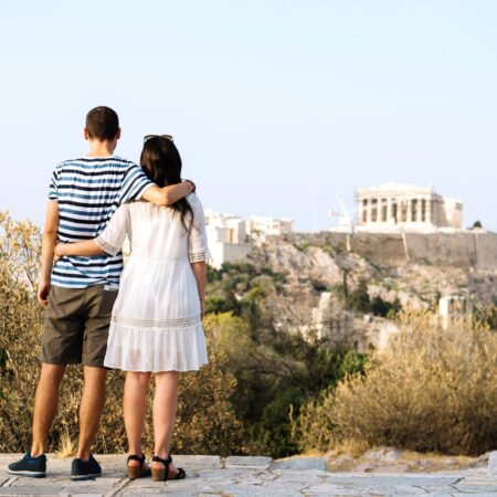 Greece, Athens, couple looking at The Acropolis and Parthenon from Areopagus.