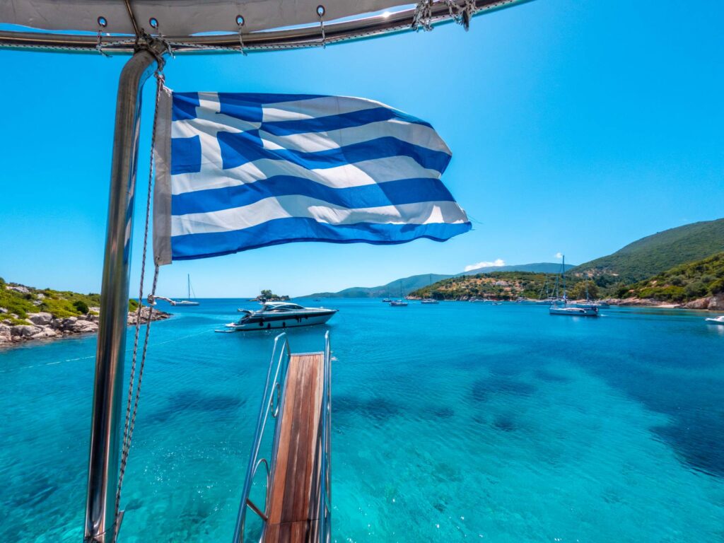 Greek flag on boat cruise around the island of Ithaki or Ithaca in the Ionian sea