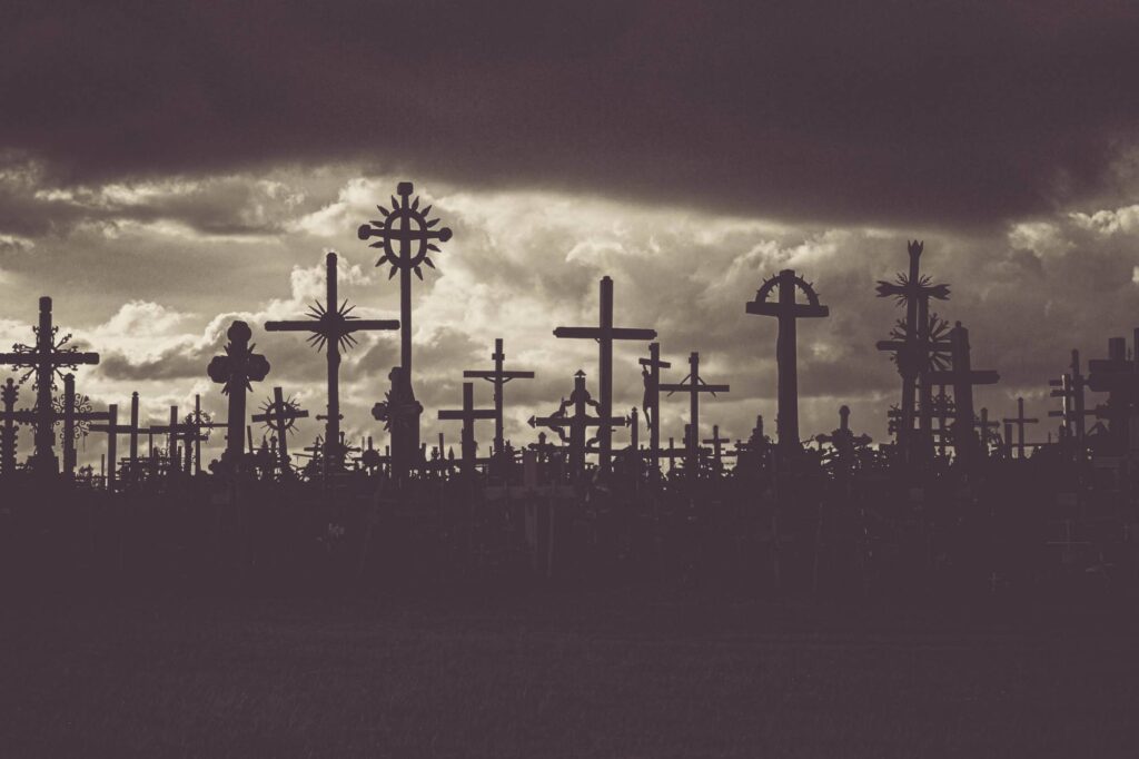 Hill of crosses in Lithuania with back lit sun and silohetted crosses