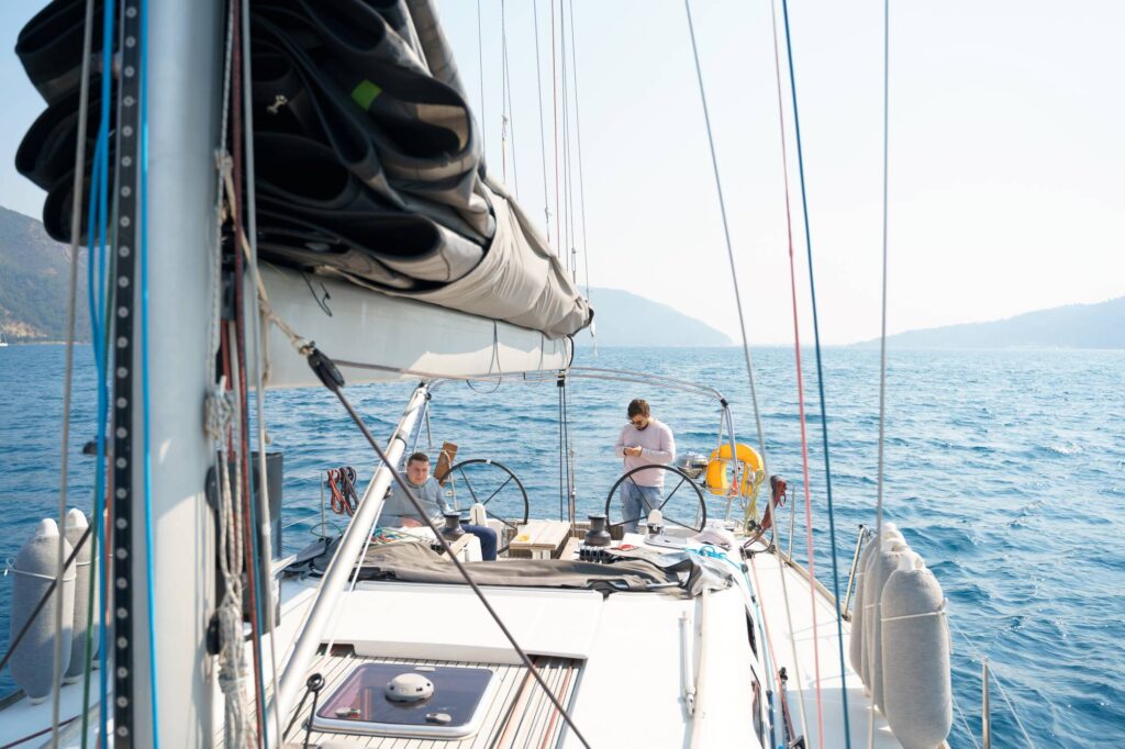 Businessman, owner with mobile phone at steering wheel in voyage sail on sport sea luxury yacht.