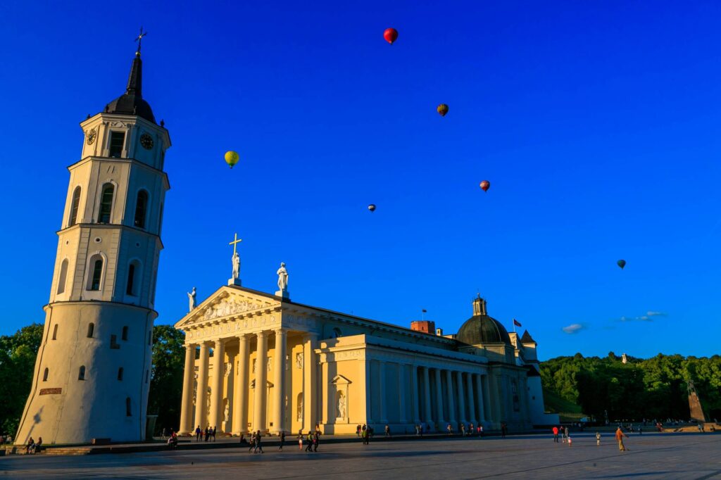 Vilnius Cathedral and bell town in the square with hot air balloons going over them