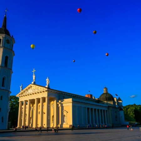 Vilnius Cathedral and bell town in the square with hot air balloons going over them