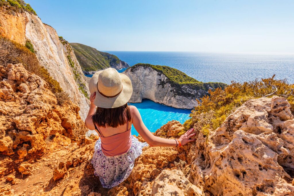 Woman tourist in Zakynthos, Greece admiring the Navagio beach